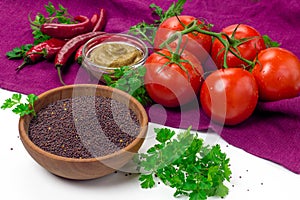 Black mustard seeds in wooden bowl and fresh vegetables.