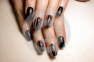 Black nail polish. Manicured nail with black nail polish. Manicure with dark nailpolish. Black nail art manicure