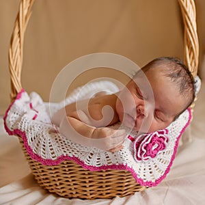 Black newborn baby sleeping in basket.