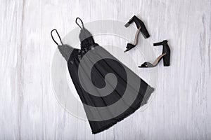 Black nightie and shoes on a wooden background. Fashion concept