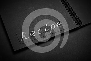 Black notebook on a black table. Notebook for recipes with blank for text