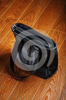 Black notebook peeking out of the pocket of a black leather bag close-up, macro Handmade, natural materials