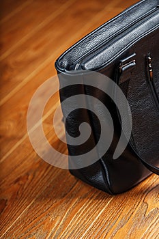 Black notebook peeking out of the pocket of a black leather bag close-up, macro Handmade, natural materials