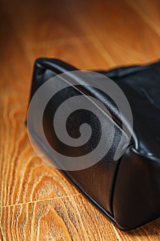 Black notebook peeking out of the pocket of a black leather bag close-up, macro Handmade, natural materials