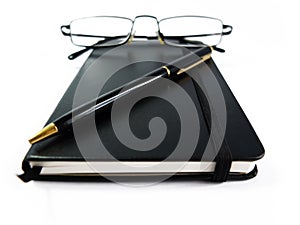 Black Notebook with Pen and Glasses Isolated on White