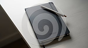 Black Notebook and Pen on White Desk