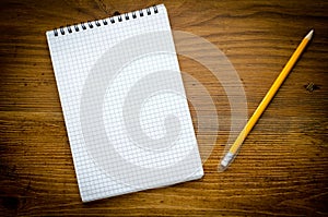 Black notebook with pencile on a wood background