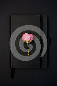 Black notebook with a rose on it