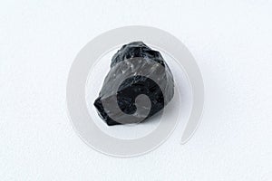 Black Obsidian stone on a white background. Natural glass. Black mineral gem