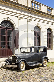 Black and obsolete car on one of the cobblestone streets, in the city of Colonia del Sacramento, Uruguay. It is one of the oldest