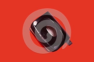 Black office hole puncher on red background