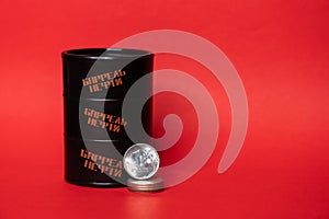 Black oil barrel with a one ruble coin on a red background