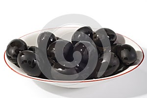 Black olives in a white bowl close up