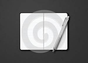 Black open lined notebook with a pen isolated on dark background