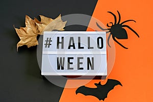 Black-orange background with golden leaves and decorative spider and bat. Halloween decoration, party invitation