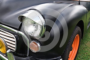 Black and orange front of vintage cars on the grass