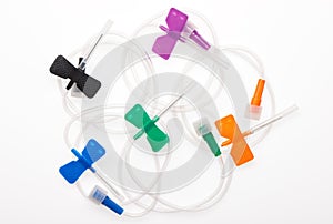 Black, orange, green, blue and purple butterfly plastic catheters with needles closed by protective caps