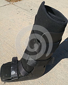 A black Orthopedic or medical boot, cast or footwear