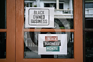 Black owned business and black business month sign were attached on the window photo