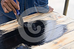 Black paint with brush on wood.