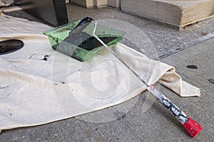 Black paint in a green roller tray outdoors enamel paint with throw down tarp