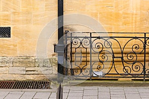 Black painted rain drainage on sand stone wall with wrought iron