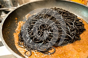Black pasta squid ink in a pan - italian taglierini al nero di seppia photo