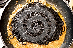 Black pasta squid ink pan up view italian taglierini al nero di seppia photo