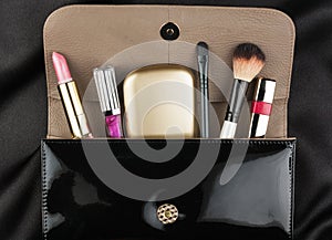 Black patent leather bag with cosmetics