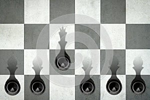 Black pawn with the shadow of the queen, in front of the pawns. Top view. Leadership concept. Strength and aspirations