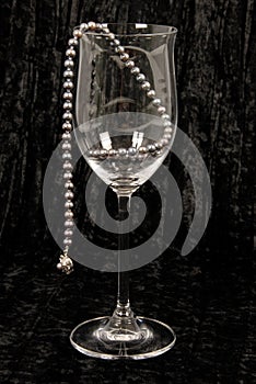 Black pearls in wine glass.