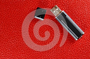 Black Pen Drive on red leather background
