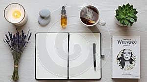 A black pen rests on a light wooden surface accompanied by a lit