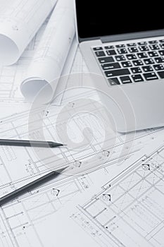 Black pencil and computer laptop on architectural drawing paper