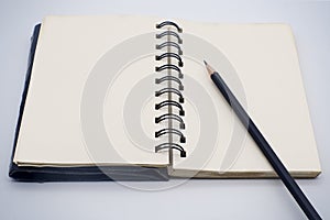 Black pencil on open white paper note book