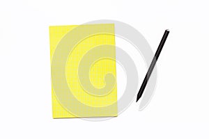 Black pencil and a yellow Notepad on a white background. Minimal business concept office Desk.