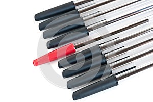 Black pens with a red one