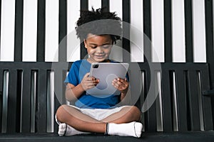 Black people African American child play tablet at home