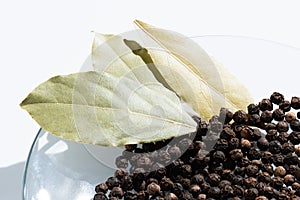 Black pepper and bay leaf in a glass bowl