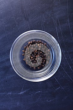 Black pepper in bowl on black background