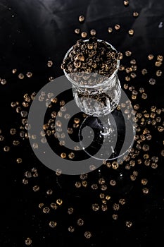 Black pepper in glass with dark background