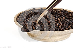 Black Pepper on Old Spoon and Stone Bowl