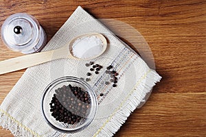 black pepper peas in a glass bowl on a linen napkin, salt mill on a wooden kitchen table