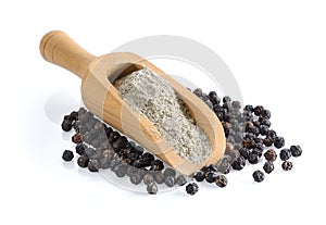 Black pepper powder in wood scoop on white background