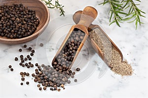 Black pepper seeds and Black pepper ground on marble background. Piper nigrum