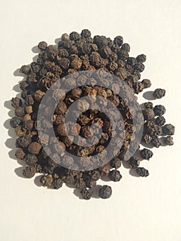 Black pepper seeds pile from top on white background