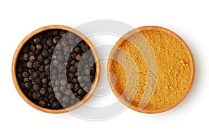 Black pepper and turmeric in wooden bowl on white background - Concept of turmeric and black pepper combination