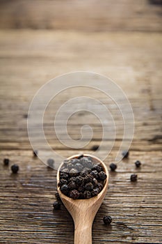 Black pepper on wooden background