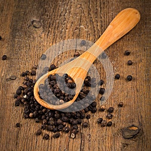 Black pepper on wooden spoon