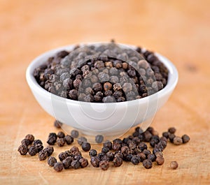 Black peppercorn on wooden background